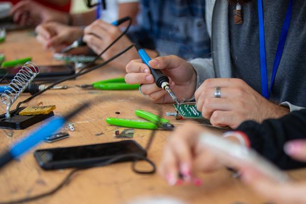 A group of people working on electronics
AI-generated content may be incorrect.