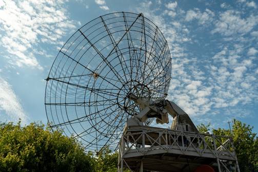 A large satellite dish on a platform
AI-generated content may be incorrect.